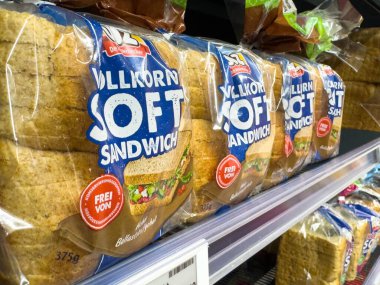 Villach, Avusturya - 10 Aralık 2025: Tam tahıllı sandviç paketleri bir süpermarket rafına düzgünce yerleştirilmiş, çekici tasarımları ve sağlık faydaları vurgulanmıştır