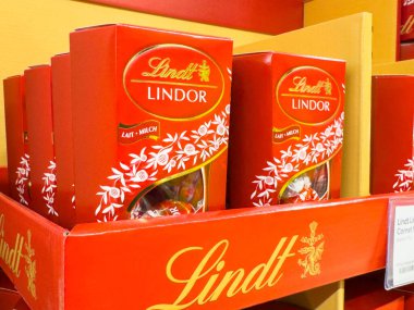 Villach, Avusturya - 10 Aralık 2025: Lindt Lindor çikolata kutuları renkli bir rafta sergileniyor, zengin tatları ve çekici tasarımı ön plana çıkarıyor