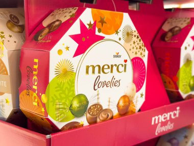 Villach, Avusturya - 10 Aralık 2025: Merci Lovelies çikolata kutusu açık bir şekilde pembe bir rafta, renkli tasarımı ve şenlikli cazibesinin altını çiziyor