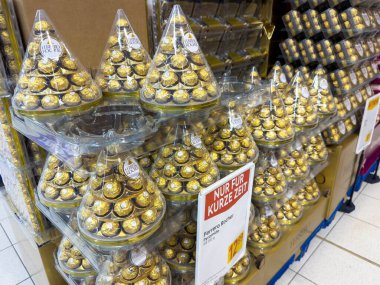 Villach, Avusturya - 10 Aralık 2025: Ferrero Rocher çikolataları piramit şeklinde sergilenerek güzel bir şekilde düzenlenmiştir.