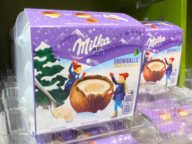 Villach, Avusturya - 10 Aralık 2025: Milka Snowballs çikolata kutusu çocuklarla eğlenceli kış sahneleri, bayram hediyeleri ve tatil keyfi için ideal