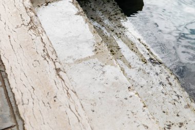 Yıpranmış doku ve yansımaları olan klasik beton havuz kenarı..