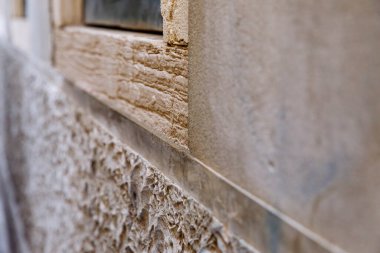 Sert ve pürüzsüz yüzeyleri olan dokulu taş duvarlara yakın çekim.