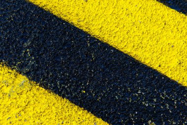 Kalın sarı ve siyah köşegen çizgiler dokulu yüzeyde yakın plan.