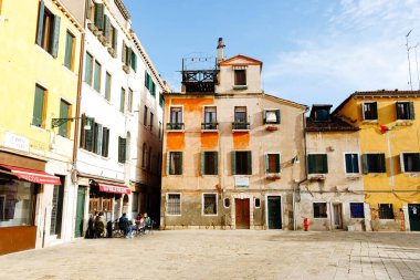 Venedik, İtalya - 05 Aralık 2025: Venedik 'teki tarihi meydanda renkli binalar, atmosfer ve ziyaretçiler ve sakinler için canlı bir atmosfer yer alıyor