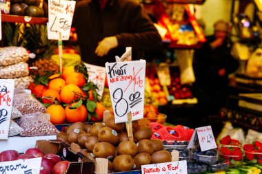 Venedik, İtalya - 05 Aralık 2025: Kivi, portakal ve elma gibi taze meyvelerle dolu renkli bir market, canlı bir alışveriş ortamı yaratıyor.