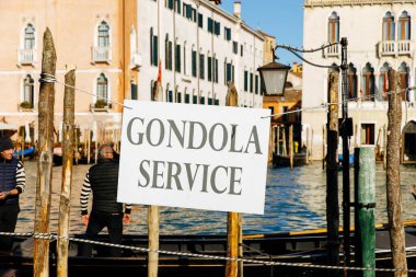 Venedik, İtalya - 5 Aralık 2025: Venedik, İtalya 'da Gondol servis tabelası, çizgili gömlekli gondolcular, yerel geleneklerin altını çiziyor.