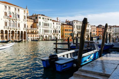 Venedik, İtalya - 05 Aralık 2025: Venedik 'teki Büyük Kanal boyunca uzanan güzel binalar, rıhtımda demirli tekneler, canlı renkler ve tarihi bir cazibe sergiliyor.