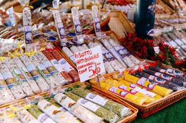 Venedik, İtalya - 05 Aralık 2025: Sanatsal risotto çeşitleri, İtalyan mutfak gelenekleri ve canlı renklerin vurgulandığı bir pazarda güzelce düzenlenmiştir