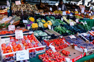 Venedik, İtalya - 05 Aralık 2025: Canlı pazar sahnesi taze meyve ve sebzelerle dolu, renkli ürünler ve müşteriler için fiyat etiketleri sergileniyor