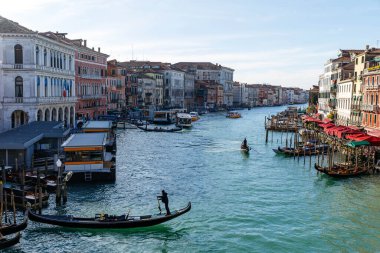 Venedik, İtalya - 05 Aralık 2025 Venedik 'teki Büyük Kanal' da süzülen Gondol renkli binalar ve canlı atmosferle çevrili