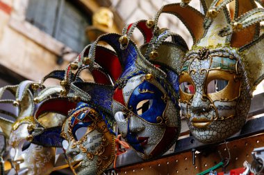 Venedik, İtalya - 05 Aralık 2025: Renkli Venedik maskeleri, karmaşık tasarımları ve şenlikli ruhlarını ön plana çıkaran canlı bir pazarda güzelce düzenlenmiştir.