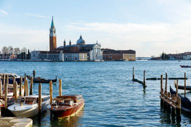 Venedik, İtalya - 05 Aralık 2025: Gondollar Venedik 'in rıhtımında demirlemiş güzel binaları ve sakin suları güzel bir manzarayla aydınlatıyorlar.