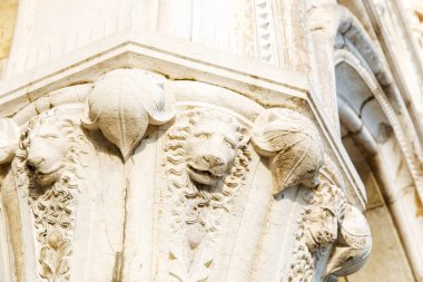 Venedik, İtalya - 05 Aralık 2025: Mimari sütun, yapının sanatsal ve tarihsel önemini vurgulayan ayrıntılı aslan oymaları ve yaprak tasarımları sergiliyor