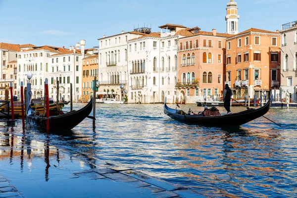 Venedik, İtalya - 05 Aralık 2025: Gondollar Venedik 'in sakin kanallarında geziniyor, güzel tarihi binalar ve parıldayan su yansımaları ile çevrili.