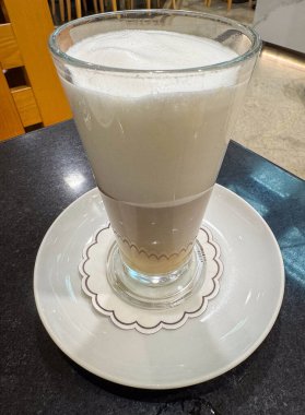 Sıcak kafede cam bardakta kremalı cappuccino..