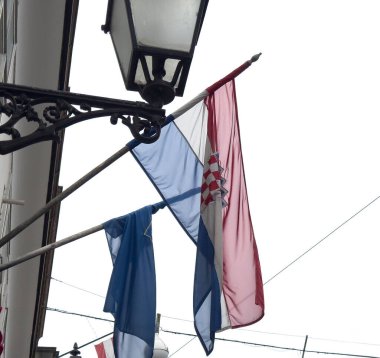 Sokak fenerinde Hırvat bayrağı ve kilise bayrağı.