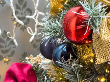 Kırmızı ve siyah süslemeli ve altın kurdeleli Noel ağacı.