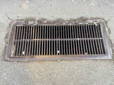 Paslı metal yağmur gideri Şehir asfalt caddesinde ızgara.