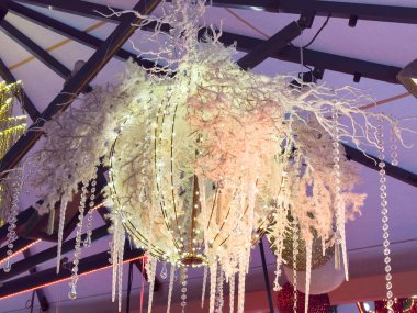 Karlı dalları ve kristal telleri olan şenlikli avize..