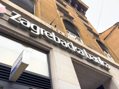 Zagreb, Hırvatistan - 14 Aralık 2025: Zagreb Bank 'ın modern tasarım unsurlarıyla dış görünüşü, kentsel mimari ve finans hizmetlerini hareketli bir şehir ortamında ön plana çıkarıyor
