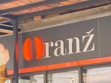 Zagreb, Hırvatistan - 14 Aralık 2025: Portakal rengi modaya uygun kafe tabelası, müşterileri ferahlatan modern tasarım unsurları içeriyor