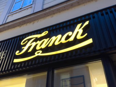 Zagreb, Hırvatistan - 14 Aralık 2025: Mağaza vitrininde aydınlatılmış Franck tabelası modern bir dokunuş ve cazip bir ışıltıyla kentsel atmosferi geliştiren zarif yazılar içeriyor