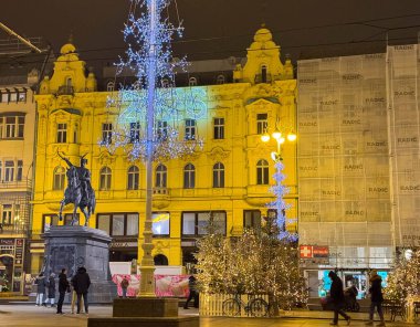 Zagreb, Hırvatistan - 14 Aralık 2025: Festivalin ışıklarıyla aydınlatılmış tarihi mimari, gece saatlerinde kent meydanında canlı bir ortam yarattı