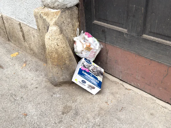 Zagreb, Hırvatistan - 14 Aralık 2025: Çöp torbası ve boş kutu, kentsel atıkları ve daha iyi bir atık yönetimi ihtiyacını gösteren eski bir kapıya yapıştırıldı