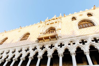 Venedik, İtalya - 19 Şubat 2025: Doge 'un Venedik Sarayı parlak mavi gökyüzü altında çarpıcı Gotik mimari ve karmaşık tasarımlar barındırır.