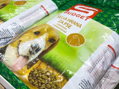 Zagreb, Hırvatistan - 17 Aralık 2025: Bütçe köpek maması paketinde yeşil çimenli gülümseyen bir köpek yavrusu sergileniyor, kaliteli hayvan beslenmesi ve köpeklere bakılması vurgulandı