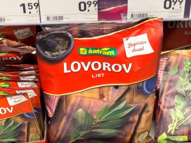 Zagreb, Hırvatistan - 17 Aralık 2025: Marketteki ahşap rafta bulunan Safram defne yaprağı paketi, canlı renklerini vurgulayarak ve yemek pişirmek için cazip bir tasarım