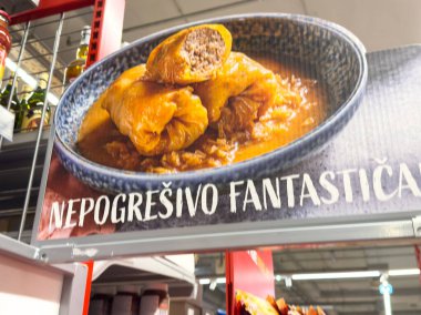 Zagreb, Hırvatistan - 17 Aralık 2025: Lezzetli sosla doldurulmuş lahana ruloları renkli bir market ortamında sergileniyor