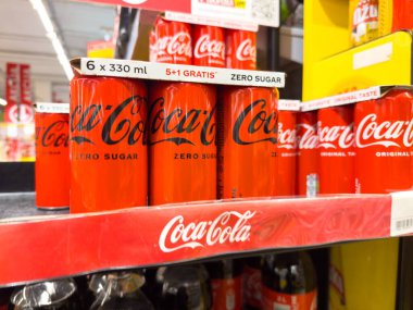Zagreb, Hırvatistan - 17 Aralık 2025: Coca-Cola Sıfır Şeker kutuları açık kırmızı renk ve tanıtım ayrıntılarını vurgulayarak bir mağaza rafına güzelce yerleştirildi