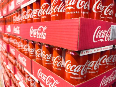 Zagreb, Hırvatistan - 17 Aralık 2025: Parlak kırmızı paketlerde istiflenmiş Coca-Cola kutuları, popüler içeceğin markalaşma ve cazibesini vurgulayarak dikkat çekici bir görüntü yarattı