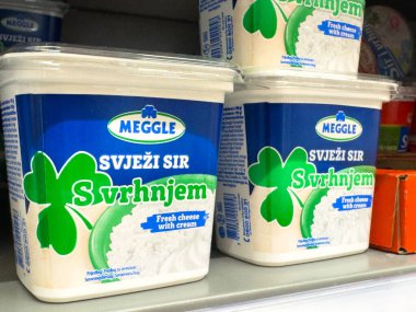 Zagreb, Hırvatistan - 17 Aralık 2025: Kremalı Meggle taze peyniri bir süpermarket rafında sergilenerek cazip ambalaj ve yonca motifinin altı çizildi