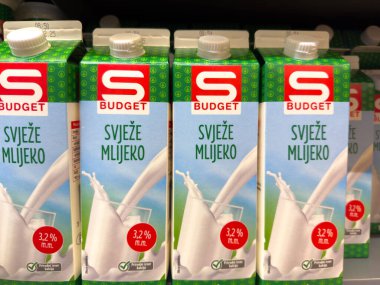 Zagreb, Hırvatistan - 17 Aralık 2025: Bütçe markalı süt kutuları, ferahlık ve cazip ambalaj tasarımı ön plana çıkarılarak bir süpermarket rafına düzgünce yerleştirildi