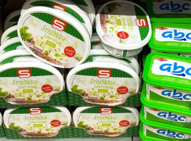 Zagreb, Hırvatistan - 17 Aralık 2025: Bütçe krem peynir yayma kapları, renkli ambalajlar ve fotokopi alanı olan çeşitli tatların yer aldığı bir süpermarket rafına düzgünce yerleştirildi