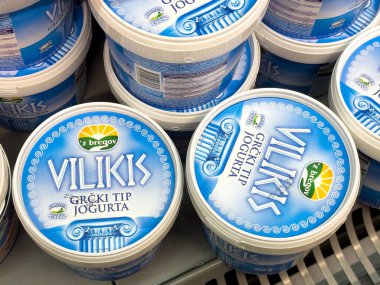 Zagreb, Hırvatistan - 17 Aralık 2025: Vilikis Yunan yoğurt konteynerleri, çekici mavi ambalaj ve markalaşmalarını ön plana çıkaran bir bakkalda düzenli olarak düzenleniyor