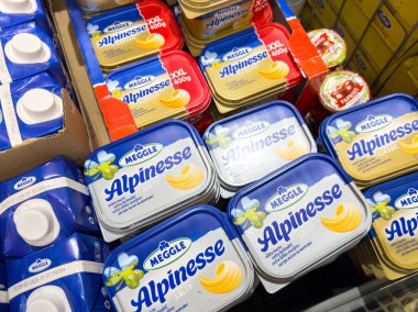 Zagreb, Hırvatistan - 17 Aralık 2025: Markette sergilenen Meggle Alpinesse süt ürünleri, canlı paketleme ve tüketici seçimi için farklı boyutlarda