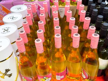 Zagreb, Hırvatistan - 17 Aralık 2025: Pembe kapaklı gül şarabı şişeleri, canlı renklerini ve perakende ortamda cazip etiketlerini vurguluyor