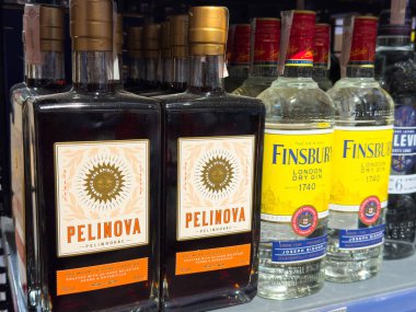 Zagreb, Hırvatistan - 17 Aralık 2025: Pelinova bitkisel likör şişeleri Finsbury London Dry Cin ile birlikte bir rafta sergilenerek ürün çeşitliliği ve markalaşması vurgulandı