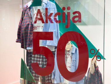 Zagreb, Hırvatistan - 17 Aralık 2025: Giyim mağazasının vitrininde sergilenen şık ekose gömlekler, tanıtım tabelalarında% 50 'lik bir indirimle müşterileri moda anlaşmalarını keşfetmeye davet etti