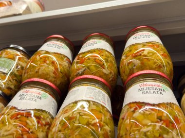 Zagreb, Hırvatistan - 17 Aralık 2025: Karışık salata kavanozları bir süpermarket rafına yerleştiriliyor, taze sebzeler ve sağlıklı beslenmek için çekici renkler vurgulanıyor