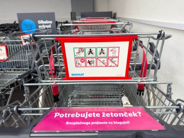 Bled, Slovenya - 17 Aralık 2025: Alışveriş arabaları bir süpermarkette düzenli olarak düzenleniyor, talimatlar ve markalaşma gösteriliyor, organize bir alışveriş ortamı yaratılıyor