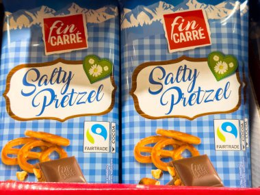 Bled, Slovenya - 17 Aralık 2025: Fin Carre tuzlu kraker paketleri canlı mavi kareli tasarım ve Fairtrade sertifikası içeren bir rafta sergileniyor