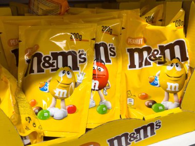 Bled, Slovenya - 17 Aralık 2025: Parlak renkli yer fıstığı M & M 'nin şeker paketleri oyuncu karakterler ve çekici grafiklerin yer aldığı bir mağaza rafına yerleştirildi