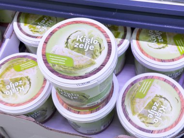 Bled, Slovenya - 17 Aralık 2025: Popüler mayalanmış lahana tabağı Kislo zelje kapları, renkli ambalajlı bir bakkalda güzelce düzenleniyor