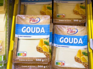 Bled, Slovenya - 17 Aralık 2025: Pilos Gouda peynir dilimleri bir süpermarket rafında düzgün bir şekilde düzenlenerek, çekici ambalaj ve ürün detaylarının altı çizildi