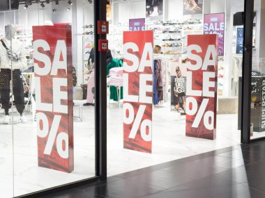 Zagreb, Hırvatistan - 17 Aralık 2025: Parlak renkler ve büyük metinlerin yer aldığı perakende mağaza vitrinlerinde satış tabelaları görülüyor, müşterileri anlaşmalara girip anlaşmaları keşfetmeye teşvik ediyor